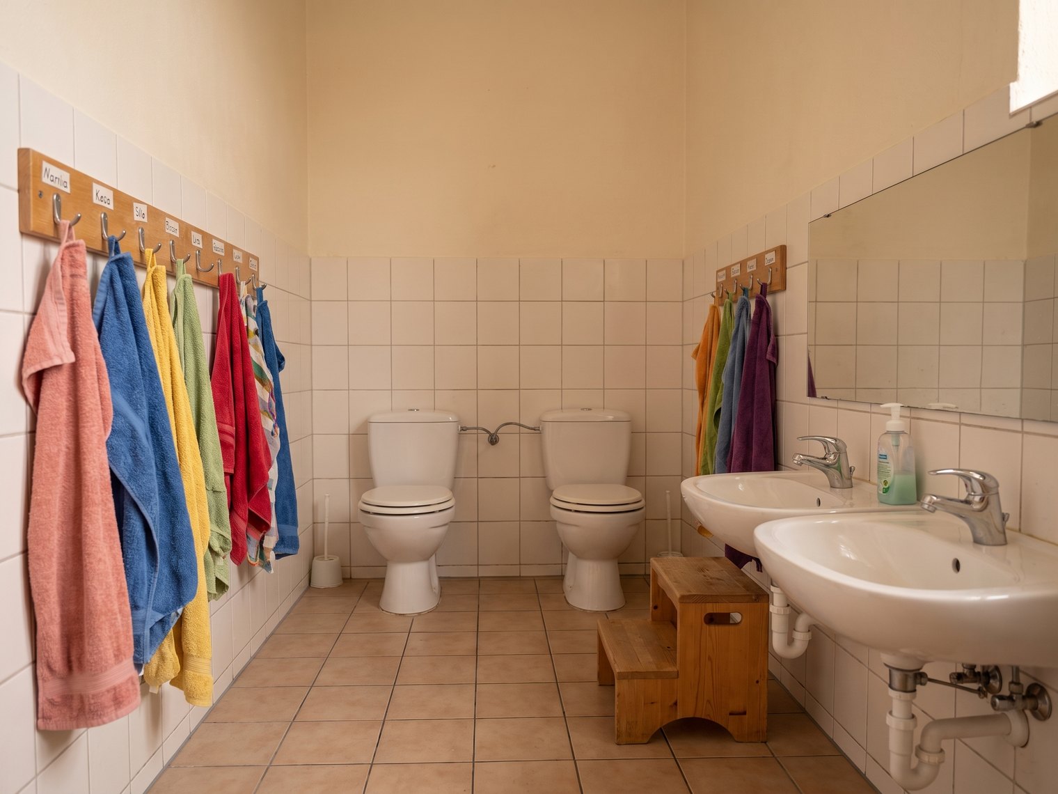 Kindertoilette mit kleinen Toiletten und niedrigen Waschbecken.